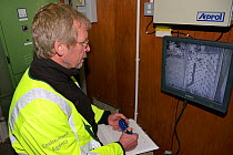 Geoff Way of the Environment Agency counting European eel (Anguilla anguilla) elvers using an eel pass beside a weir on a drainage channel on the Somerset Levels by reviewing remote infra red video fo...