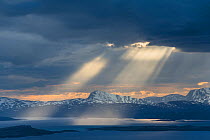 Sunbeams from dark clouds above Lake Virihaure in Padjelanta National Park, Laponia World Heritage Site, Swedish Lapland, Sweden.