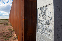 Border wall constructed of welded steel, between Arizona and Sonora, Mexico cutting through the Sonoran Desert. Pinacate and Grand Desert Biosphere Reserve, Mexico. January 2009.