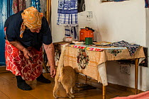 Woman living in the Chernobyl Exlusion Zone feeding cat, Ukraine September