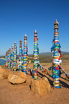 Coloured ribbons on the sacred poles at Shaman rock, Cape Burhan, Olkhon Island, Lake Baikal, Siberia, Russia.