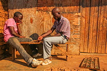 Two young men play a game called Bao in the back alleys of a marketplace in Lilongwe, Malawi.