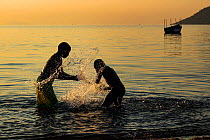 Boy and girl playing in Lake Malawi at sunset, Cape Maclear, Malawi. June 2011