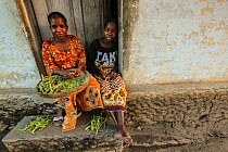 Woman shelling green beans outside of her house in Mossuril, northern Mozambique. June 2011