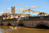 Crane removing debris piling up against the River Severn bridge in Worcester after a period of heavy rain, Gloucestershire, February 2014.