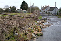 Road closed and collapsed stone wall caused by serious flooding after weeks of heavy rain, Long Lode, Somerset Levels, UK, February 2014.
