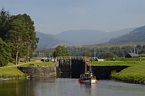 Classic wooden yacht approaching a lock  on the Caledonian canal at Gairlochy, Lachaber, Scotland, UK, September 2016.