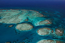 Aerial view of southern Belize barrier reef near Placencia, showing reef bend at Gladden Spit, Gladden Spit and Silk Cayes Marine Reserve. With two tour boats inside the reef, and three fishing boats...