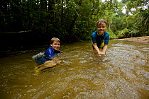 Russell and Jessica Laman playing in the river at the Cabang Panti Research Site, Gunung Palung National Park, Borneo. August 2010