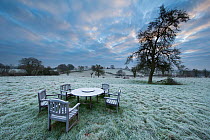 Garden table at dawn covered in frost, Shropshire, England, December 2014.