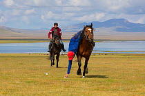 Horse riders showing skill in traditional game picking up money from ground whilst horseback, Song Kul Lake, Kyrgyzstan, August 2016.