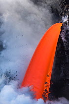 Hot lava from the 61G flow from Kilauea Volcano entering the Pacific Ocean from the open end of a lava tube at the Kamokuna entry in Hawaii Volcanoes National Park, producing steam explosions, Kalapan...