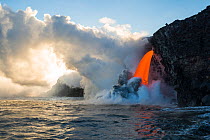 Hot lava from the 61G flow from Kilauea Volcano entering the Pacific Ocean from the open end of a lava tube at the Kamokuna entry in Hawaii Volcanoes National Park, producing steam explosions, Kalapan...