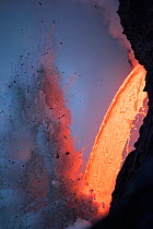Hot lava from the 61G flow from Kilauea Volcano entering the ocean from the open end of a lava tube at the Kamokuna entry in Hawaii Volcanoes National Park, producing steam explosions, Kalapana, Puna,...