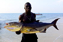 Man holding large fish caught in Atlantic Ocean, Island of Orango, Orango Islands National Park, Bijagos UNESCO Biosphere Reserve, Guinea Bissau, February 2015.