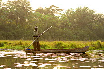 Fisherman standing in dug out canoe,   Lagoons of Cufada ( Lagoas de Cufada)  Natural Park, Guinea Bissau. February 2015