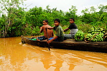 Family travelling in canoe on the Rio Platano, Rio Platano Biosphere Reserve and UNESCO World Heritage Site, La Mosquitia, Honduras