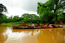 Family travelling in dugout canoe, Rio Platano Biosphere Reserve and UNESCO World Heritage Site,  La Mosquitia, Honduras.
