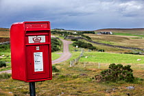 Traditional Royal Mail red mailbox in the countryside at Coigach, Ross and Cromarty, Scottish Highlands, Scotland, UK, September 2016.