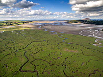 Aerial view of saltmarsh with small meandering drainage tributaries. River Dwyryd estuary and village of Portmeirion in background, Glastraeth, Talsarnau, Gwynedd, Wales, UK, October 2016.