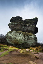 Rock pedestal created by variable erosion of soft and hard layers of carboniferous age millstone grit, Brimham Rocks, Harrogate, Yorkshire, England, UK, October 2016.