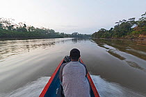 Man on canoe in the Chucunaque River at dawn in search of the Harpy Eagle, Darien National Park UNESCO World Heritage Site, Panama. February 2017.