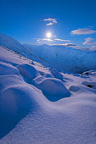 Moonrise above Ben Cruachan and Stob Diamh with snowdrift in foreground, Scotland, UK, February 2017.