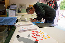 People signing a petition calling for a state regulated system of game bird hunting on grouse shooting estates. Hen Harrier Day, Loch Leven, Kinross, Scotland, UK, August 2016.
