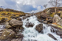 Idwal Falls on the path from Idwal Cottage by Llyn Ogwen up to Llyn Idwall and the Devil's Kitchen with the summit of Y Garn in the background Snowdonia North Wales, UK, March 2017.