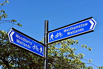 Fingerpost / guide post sign to Woodberry Wetlands and Walthamstow Wetlands against blue sky, London Borough of Hackney, England, UK, August 2016.