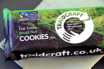 Packet of Traidcraft Fairtrade or Fair Trade Cookies or biscuits on embroidered green cloth, London, UK.