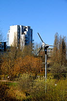 Wind turbine in urban setting with flats behind, Mile End Park London Borough of Tower Hamlets, England, UK, March 2014.