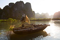 Fisherman in Ha Long Bay UNESCO World Heritage Site,  CatBa Island, Vietnam. December 2015.