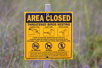 Area closed sign, due to nesting birds including Common tern, Least tern, Piping plover, Dennisport, Massachusetts, USA, August.