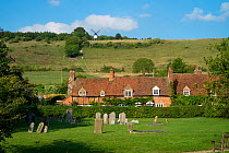 Turville Village showing the gravestones and Cobstone windmill in th distance, The Chilterns, Buckinghamshire, England, UK. September 2016.