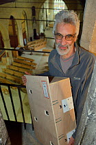 Common swift (Apus apus) nest box carried by Roger Becket into Holy Trinity church to be fitted in the bell tower, Bradford-on-Avon, Wiltshire, UK, June.