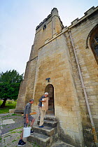 Nest box for Common swifts (Apus apus) carried by Roger Becket and Peter Grayshon into Holy Trinity church to be fitted in the bell tower, Bradford-on-Avon, Wiltshire, UK, June.
