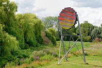 Swift tower with nest boxes for up to 100 pairs of Common swifts (Apus apus) designed as a public art work to look like a setting sun, Logan's Meadow Local Nature Reserve, Cambridge, UK, July.