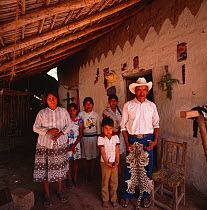 Family living near the Rio Cuchujaqui with hunted Ocelot (Felis pardalis) skin / pelt. Sierra Madre foothills, Mexico 1992