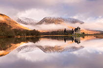 Kilchurn Castle, sunrise, early morning mist and light, a ruin on a rocky peninsula, the northeastern end of Loch Awe, in Argyll and Bute, Scotland, UK. March 2017.