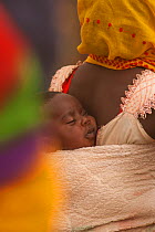 Ouled Rachid tribeswoman with baby strapped to her back, Kashkasha village near Zakouma National Park, Chad, 2010.