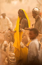 Ouled Rachid man and tribeswoman with domestic donkey, Kashkasha village near Zakouma National Park, Chad, 2010.