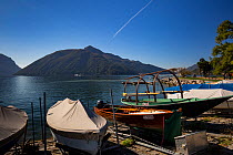Local boats on Lake Lugano with Monte San Giorgio in the background, a UNESCO World Heritage Site, Ticino, Switzerland. October 2017.