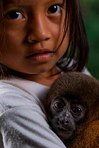 Waorani girl holding a baby Silvery woolly monkey (Lagothrix poeppigii)?? Yasuni National Park, Orellana, Ecuador.