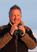 Photographer Mark Carwardine with binoculars, Baffin Island, Nunavut, Arctic Canada