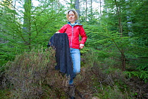 Becky Priestley, Wildlife Officer with Trees for Life, with Red squirrel (Sciurus vulgaris) caught in cage trap as part of reintroduction to the north west Highlands, Moray, Scotland, UK.