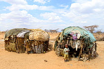 Samburu child outside improvised hut in dry landscape  near Samburu National Reserve, Kenya, September 2017.