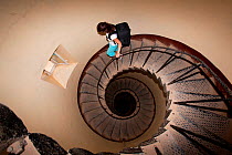 Woman walking on the long staircase inside the Lighthouse, Sanganeb reef, Sudan, Red Sea