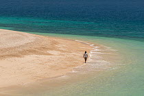 Woman walking on white sands of Fitzroy Island, Tropical Far North Queensland, Australia, December 2015. Model released.