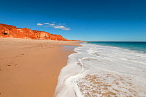 Beach waves on the white sands. Spectacular views of ochre-coloured earth and sandstone cliffs, white sands and aquamarine waters of the Dampier Peninsula is one of the most spectacular coastal enviro...